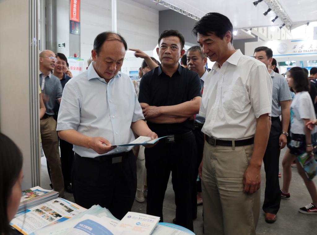 省委高教工委书记董小龙查看乐游棋牌招生宣传资料